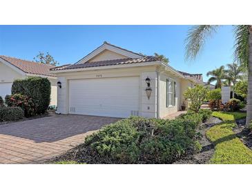 Single-story home with attached garage and landscaped front yard at 7575 Quinto Dr, Sarasota, FL 34238