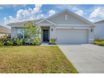 Newly constructed home with a two-car garage and well-manicured lawn at 10328 Charlotte Dr, Parrish, FL 34219