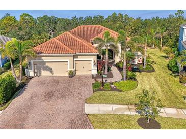 Single-Gathering home with tile roof, three-car garage, and lush landscaping at 12654 Harney St, Venice, FL 34293