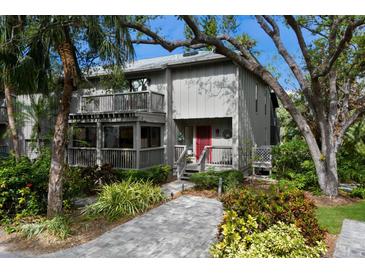 Two-story townhome with gray siding, red door, and landscaped grounds at 1479 Landings Cir # 41, Sarasota, FL 34231