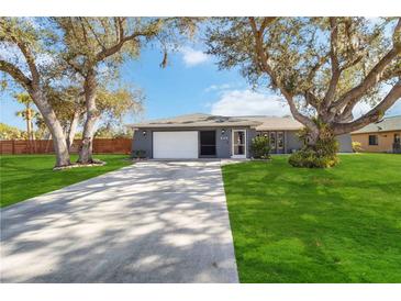 Gray house with a two-car garage and spacious lawn at 2146 Como St, Port Charlotte, FL 33948