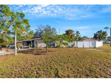 Ranch style home with large yard, mature trees, and white fence at 2416 Amherst Ave, Bradenton, FL 34207