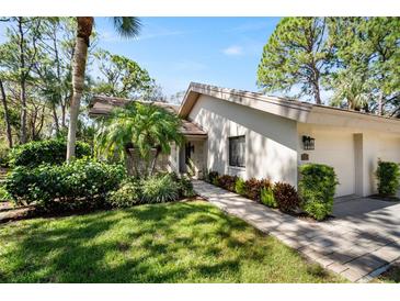 Well-maintained house exterior with landscaped yard and walkway at 3105 Sandleheath # 1, Sarasota, FL 34235