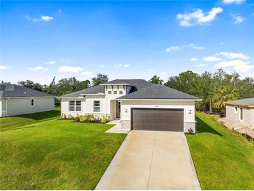 New construction home with a two-car garage and landscaped lawn at 3397 Dryden St, North Port, FL 34288