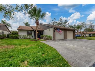 Two-car garage, attractive landscaping, and a spacious driveway at 365 Oak Hill Way # 32, Sarasota, FL 34232