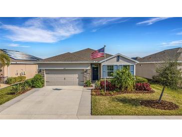 One-story home with gray siding, stone accents, and a two-car garage at 4110 Mossy Limb Ct, Palmetto, FL 34221