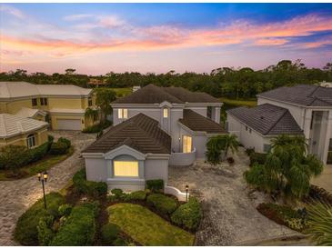 Luxury home with a tile roof and a meticulously landscaped yard at 7716 Club Ln, Sarasota, FL 34238