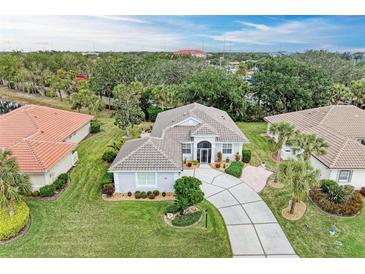 Aerial view of a beautiful home with a large backyard and surrounding neighborhood at 120 Grand Oak Cir, Venice, FL 34292