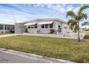 Single-wide manufactured home with carport and landscaped lawn at 1211 45Th E Ave, Ellenton, FL 34222
