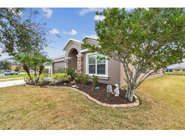 Landscaped yard with lush greenery and a two-car garage at 10605 58Th E St, Parrish, FL 34219