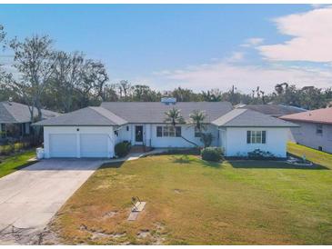 White single-story home with a two-car garage and well-maintained lawn at 2425 Riverview Blvd, Bradenton, FL 34205