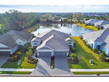 Luxury home with lake view, two-car garage, and paver driveway at 2616 Sapphire Blue Ln, Bradenton, FL 34211