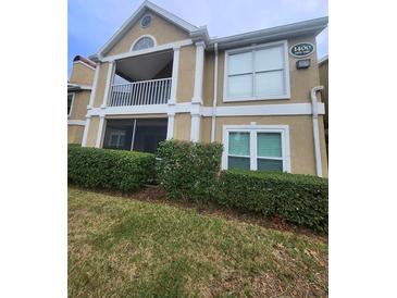 Tan two-story building with balcony and manicured landscaping at 9481 Highland Oak Dr # 1403, Tampa, FL 33647