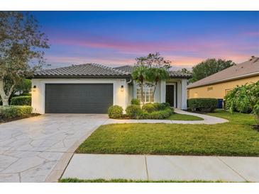 Single-story home with a gray garage door, landscaping, and a paved walkway at 10114 Glenmore Ave, Bradenton, FL 34202
