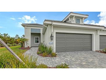 Single-story home with gray garage door and paved driveway at 12681 Palatka Dr, Venice, FL 34293