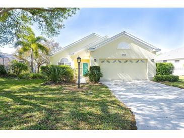 Charming yellow house with a two-car garage and manicured lawn at 12732 Rockrose Gln, Lakewood Ranch, FL 34202