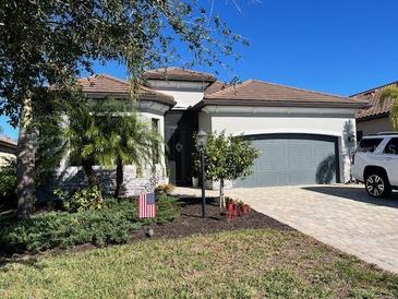 Single-story home with gray garage door, landscaping, and a paved driveway at 17601 Hickok Belt Loop, Bradenton, FL 34211