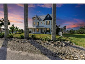 Two-story house with a metal roof, and a wrap-around porch at 1825 Bayshore Dr, Terra Ceia, FL 34250