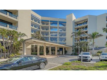 Condo building exterior featuring attractive landscaping and ample parking at 2110 Harbourside Dr # 522, Longboat Key, FL 34228