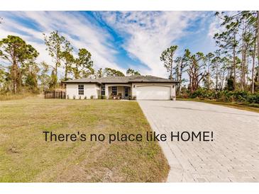 Single-story home with a paved driveway and landscaped lawn at 3164 Lotus Rd, North Port, FL 34291