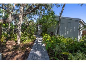 Brick walkway leads to charming home entrance, surrounded by lush landscaping at 752 Tropical Cir, Sarasota, FL 34242