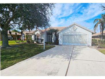 Single-story home with a tile roof, attached garage, and landscaped lawn at 8282 Parkside Dr, Englewood, FL 34224
