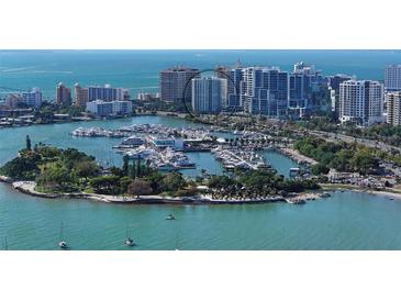 Aerial view of waterfront property, showcasing a luxury highrise building and marina at 1111 N Gulfstream Ave # 3E, Sarasota, FL 34236