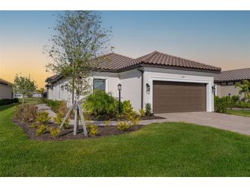 Single-story home with brown garage door, landscaping, and a paved driveway at 16127 Fortezza Dr, Bradenton, FL 34211