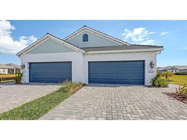 Two-car garage and front landscaping of a new home at 21628 Lake Placid Way, Venice, FL 34293