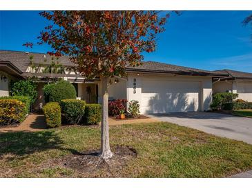 Charming home with a well-maintained lawn, manicured shrubs, and a two-car garage at 3663 Muirfield Dr # 4B, Sarasota, FL 34238