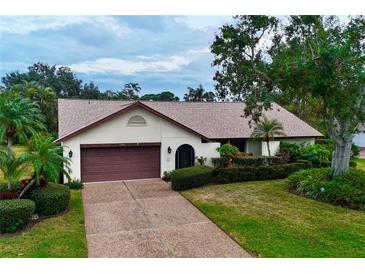 Single-story house with brown garage door and landscaped lawn at 3947 Country View Dr, Sarasota, FL 34233