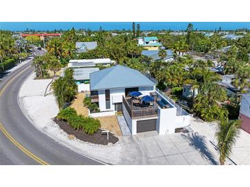 Aerial view of a single-Gathering home with a detached garage and ocean access at 5613 Gulf Dr, Holmes Beach, FL 34217