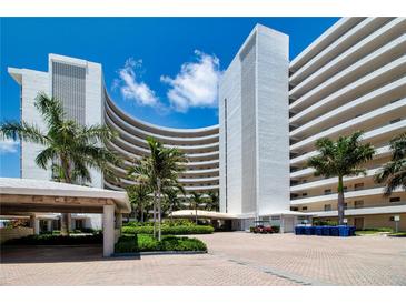 Oceanfront condo building with palm trees and courtyard at 6300 Midnight Pass Rd # 708, Sarasota, FL 34242