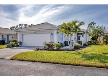 Single-story home with a two-car garage and lush landscaping at 1570 Monarch Dr, Venice, FL 34293