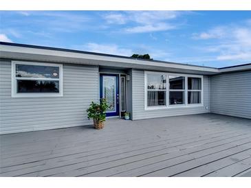 Gray house with a blue door and a large deck at 2726 Jerry Ave, Punta Gorda, FL 33950