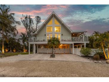 A charming two-story home with a large window and elevated deck at 315 Hammock Cir, Anna Maria, FL 34216