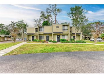 Tan colored two-story condo building with lush landscaping and a walkway at 4918 25Th W St # 102, Bradenton, FL 34207