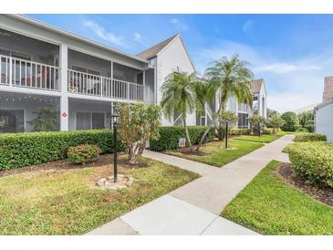Condo building with walkway, landscaping, and palm trees at 6807 Stone River Rd # 204, Bradenton, FL 34203