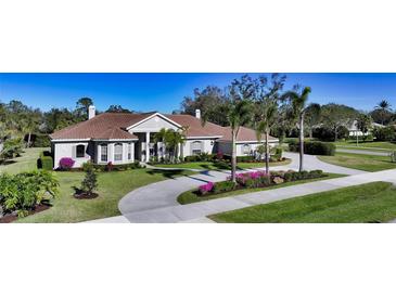 Single-story home with tile roof, palm trees, and landscaped yard at 7419 Albert Tillinghast Dr, Sarasota, FL 34240