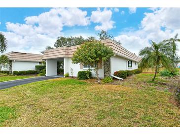 White single story home with carport and landscaped lawn at 2325 Riverbluff Pkwy # V247, Sarasota, FL 34231