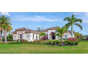 Single-story home with tile roof, landscaping, and palm trees at 4986 Antiquity Way, Sarasota, FL 34240