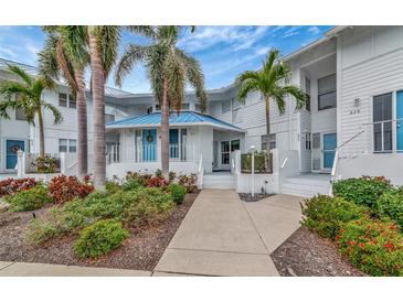 Condo building exterior, featuring a walkway and tropical landscaping at 829 Audubon Dr # 829, Bradenton, FL 34209