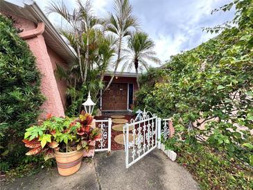 Inviting front entrance with lush landscaping and decorative gate at 1741 Font Ln, Holiday, FL 34691