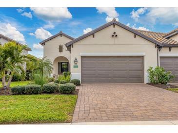 Two-story house with brown garage door and landscaped yard at 26954 Pavin Dr, Englewood, FL 34223