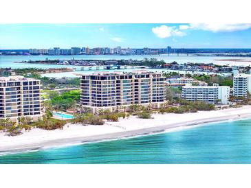 Beautiful waterfront condo building on the white sands of a beach with city views in the background at 415 L Ambiance Dr # A701, Longboat Key, FL 34228