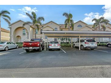 Exterior view of condo building with covered parking and landscaping at 4230 Castlebridge Ln # 1821, Sarasota, FL 34238