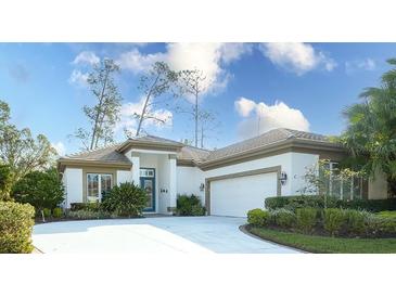 Charming single-story home featuring a two-car garage, well-manicured landscaping, and a blue front door at 4837 88Th E St, Bradenton, FL 34211
