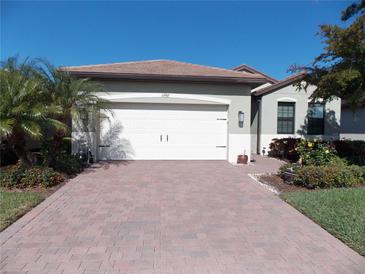 Well-maintained house with a paved driveway, landscaping, and a two-car garage at 11992 Blazing Star Dr, Venice, FL 34293