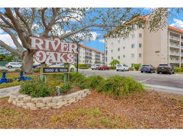 River Oaks condo complex, featuring building exterior, parking, and landscaping at 1600 1St W Ave # 304A, Bradenton, FL 34205