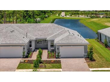 Two-unit home with attached garages and a pond view at 25917 Bimini Sands Ct, Englewood, FL 34223